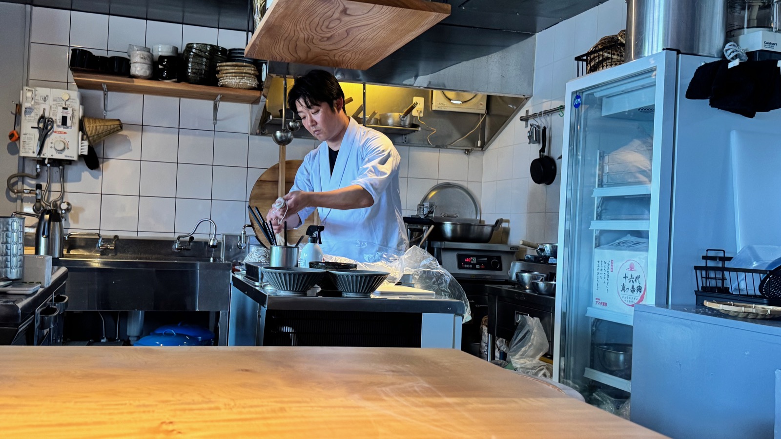 The chef at RYOMA preparing soba in the open kitchen