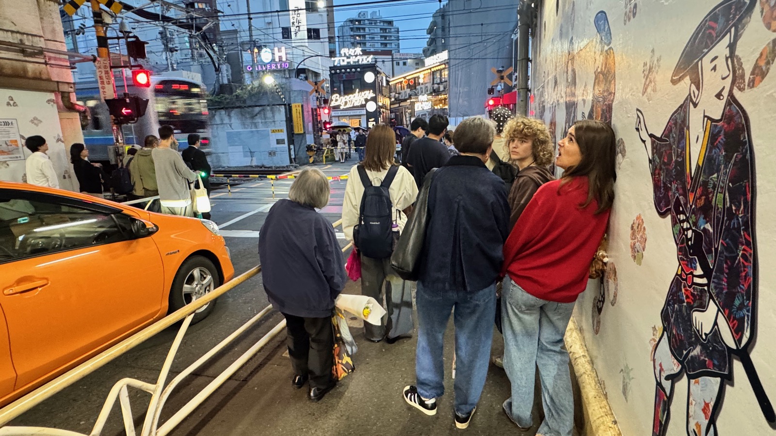 Luca and Seraphima by a Japanese mural on the evening walk to Futago