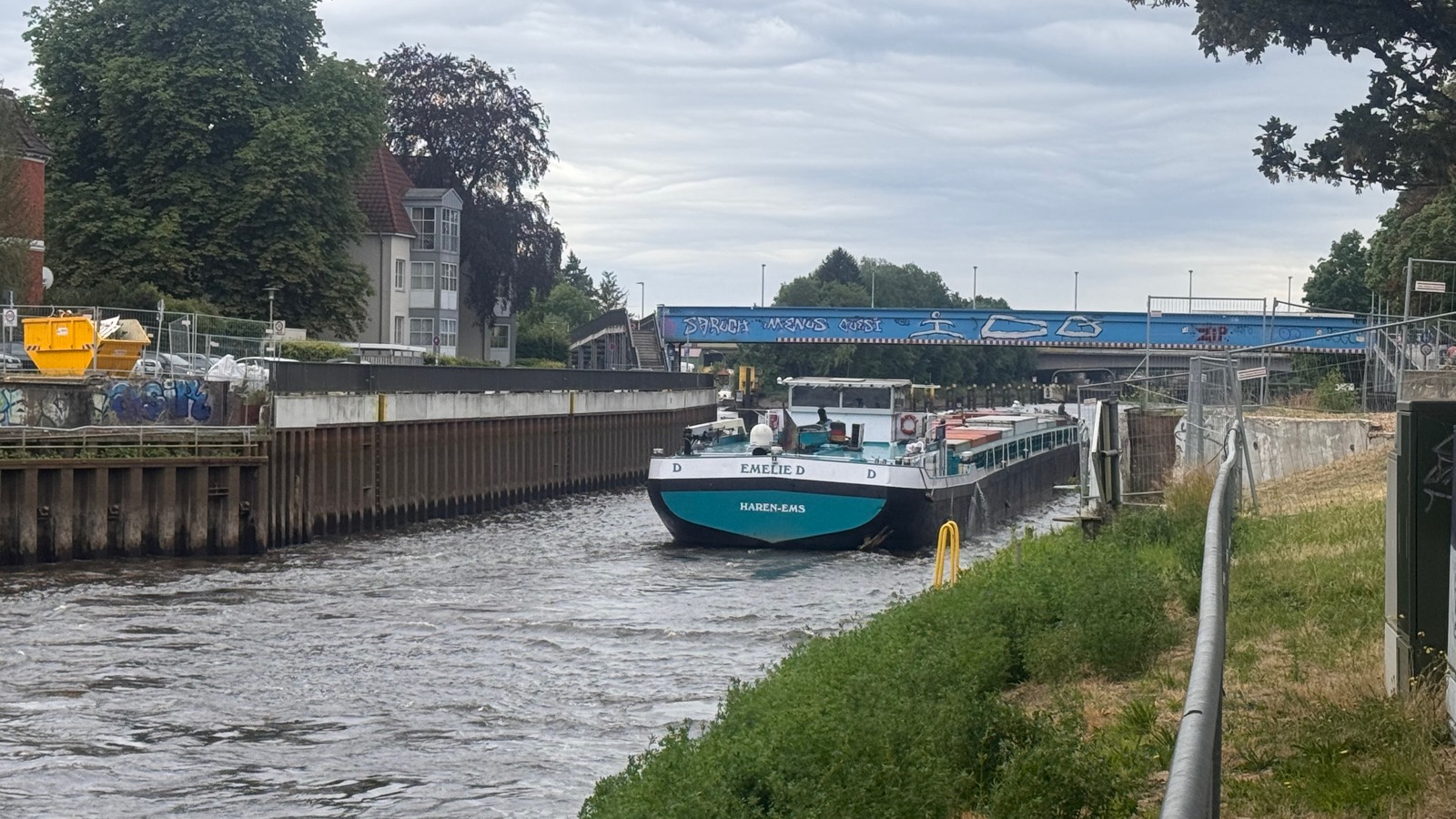 The barge Emelie D passing the canal walls at the Caecilienbruecke