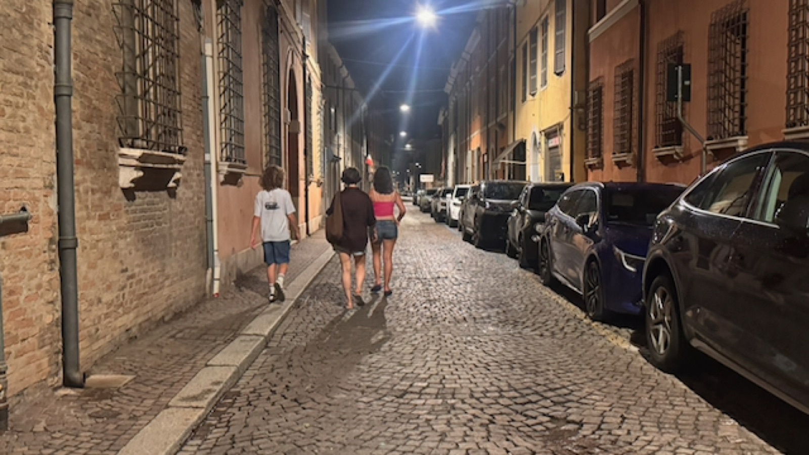 The three walking a cobbled Ravenna lane at night